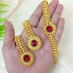 appears to be a traditional gold-plated jewelry set featuring red stones and pearl