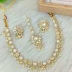 ndian-style antique Kundan jewellery set includes a necklace, earrings, and a maang tikka,