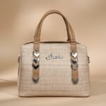 beige women's handbag with decorative straps.