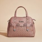 Guess Lawndale satchel bag in a mauve/pink color with a monogram pattern and laser-cut details.