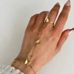 gold butterfly hand harness, often styled as a butterfly ring cum chain bracelet.