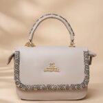 small grey top-handle satchel handbag in faux leather with a decorative trim.
