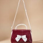 red crocodile pattern women's shoulder bag with a bow accent.