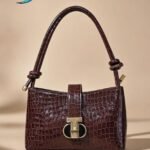 Sandro Janet leather shoulder bag in a bordeaux or dark red color.